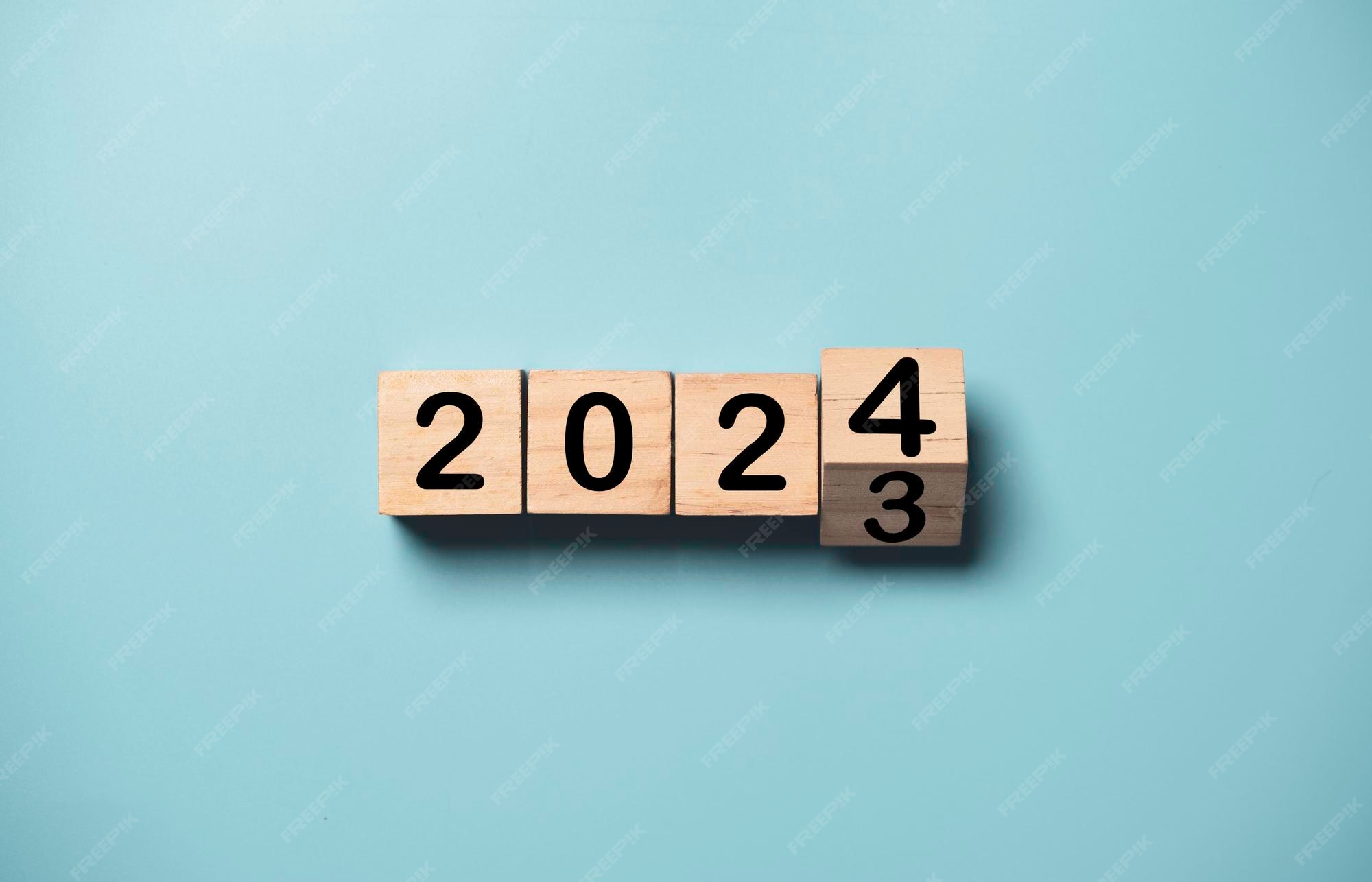 Premium Photo Flipping of 2023 to 2024 on wooden block cube for preparation new year change