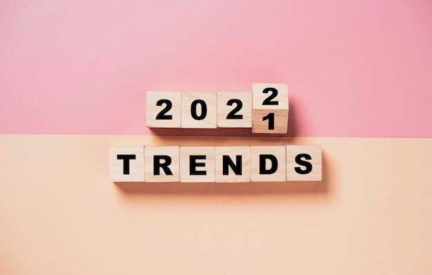 Foto flipping van 2021 tot 2022 op houten kubusblok met trendformulering voor nieuwe jaarmodetrend en bedrijfsveranderingsconcept.