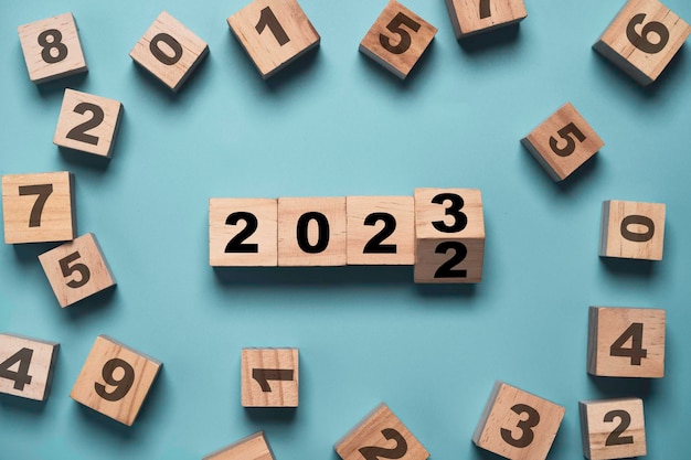 Flipping van 2022 tot 2023 op houten blokkubus met ander nummer voor voorbereiding op nieuwjaarsverandering en start nieuw bedrijfsdoelstrategieconcept.