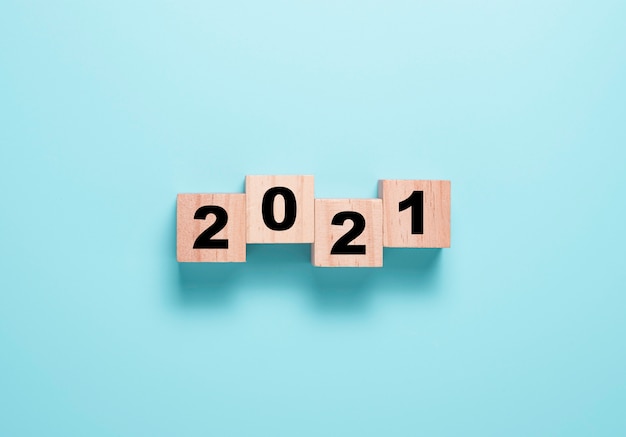 Переворачивая блок деревянных кубиков для изменения с 2020 по 2021 год. С Новым годом, чтобы начать новый проект и бизнес-концепцию.