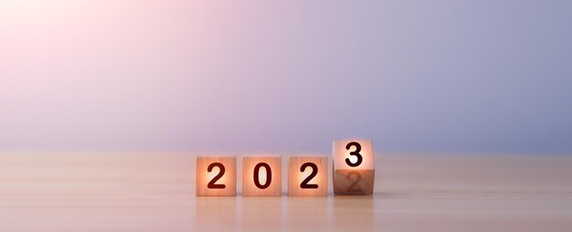 2022 年から 2023 年に木製のキューブ ブロックの変更を反転します。メリー クリスマス、新年あけましておめでとうございますの概念