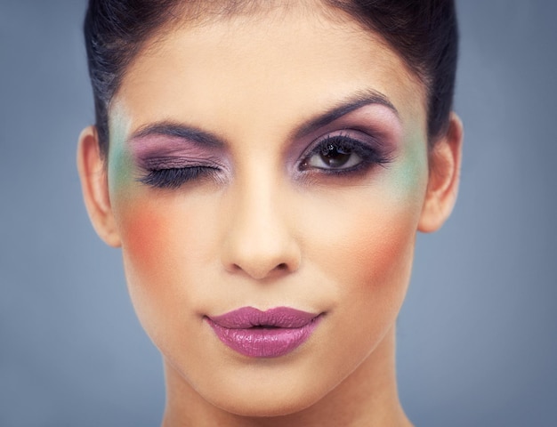 Flirten met veel kleuren Headshot van een mooie jonge vrouw met kleurrijke make-up