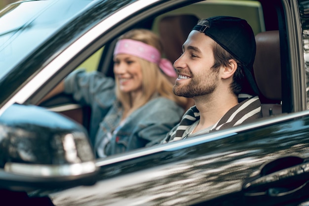 Foto flirterige stemming. glimlachend paar rijden in een auto en kijken naar elkaar