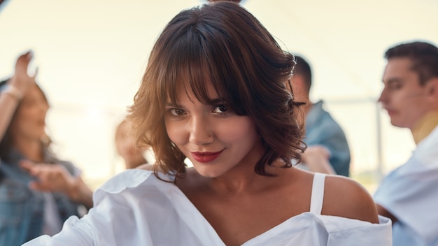 Flirty beauty pretty and young woman in white shirt is smiling and looking at camera