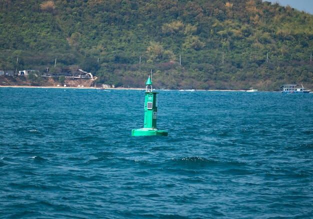 Floating green navigational buoy on blue sea Marine signal buoy Navigational Buoy marking a shipping channel