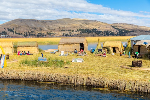 Floating Islands on Lake Titicaca Puno Peru South America thatched home Dense root that plants Khili interweave form natural layer about one to two meters thick that support islands