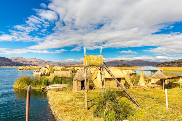 Floating Islands on Lake Titicaca Puno Peru South America thatched home Dense root that plants Khili interweave form natural layer about one to two meters thick that support islands