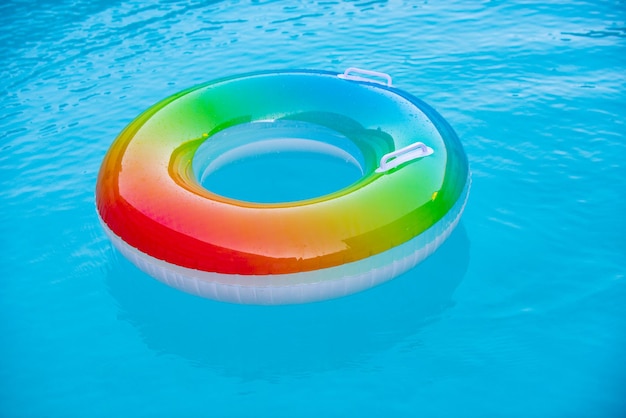 Floating ring on blue water pool with waves reflecting in the summer blue aqua textured background