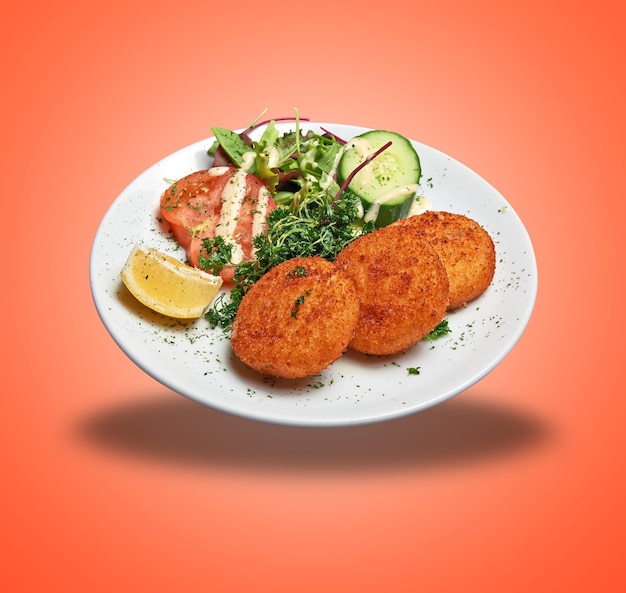 Floating white plate with three cheese croquettes ans salad