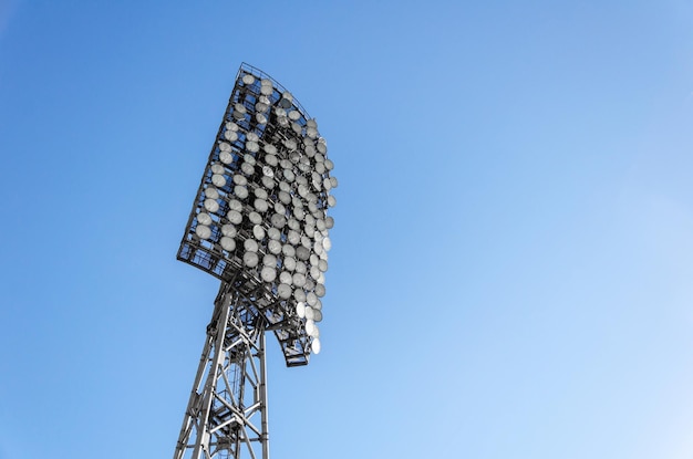 Фото Прожекторы на стадионе на фоне голубого неба высокая металлическая осветительная башня для спортивной арены