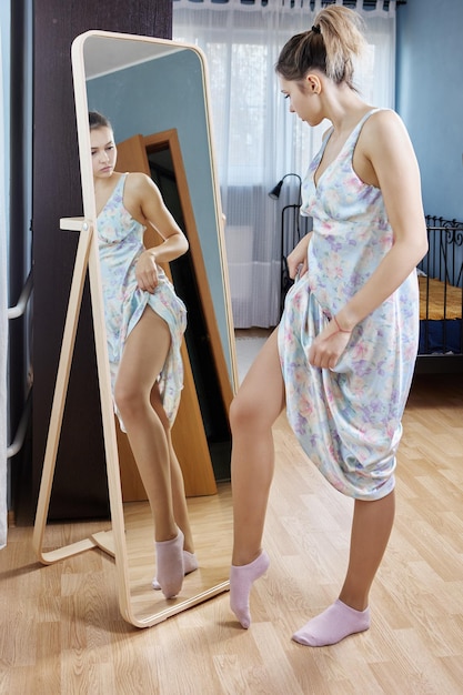 Photo floor standing fulllength mirror young woman changing clothes looking into reflection