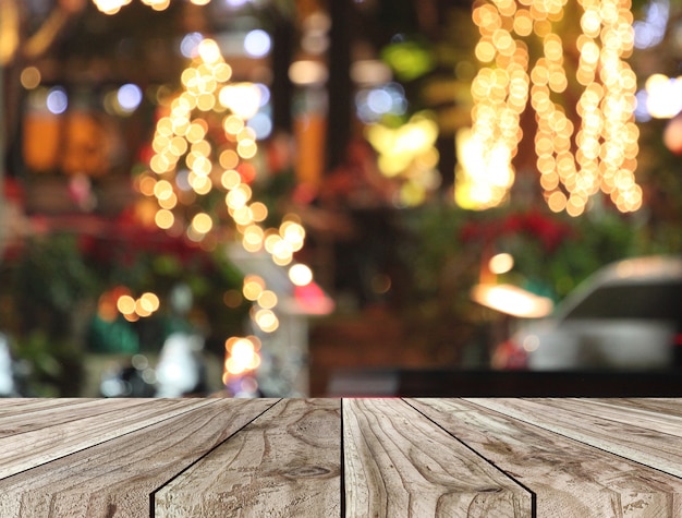 Floor of wooden table and Christmas bokeh background.