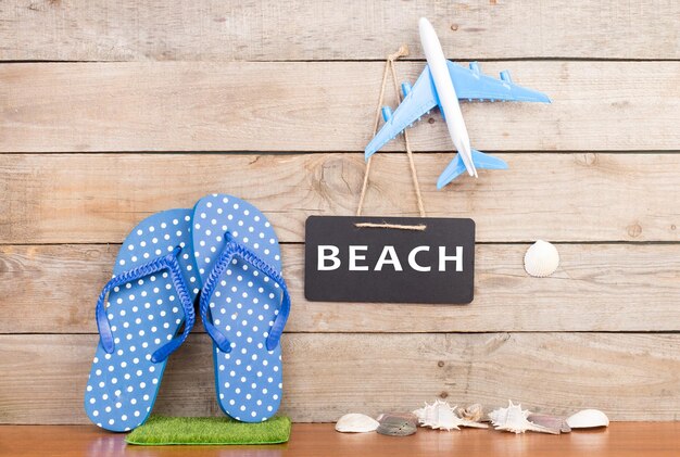 Flops toy airplane seashells and blackboard with inscription BEACH