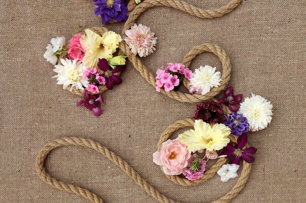 Floral arrangement of various flowers on burlap.