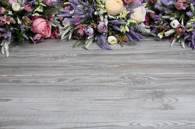 Floral arrangement on wooden texture background.