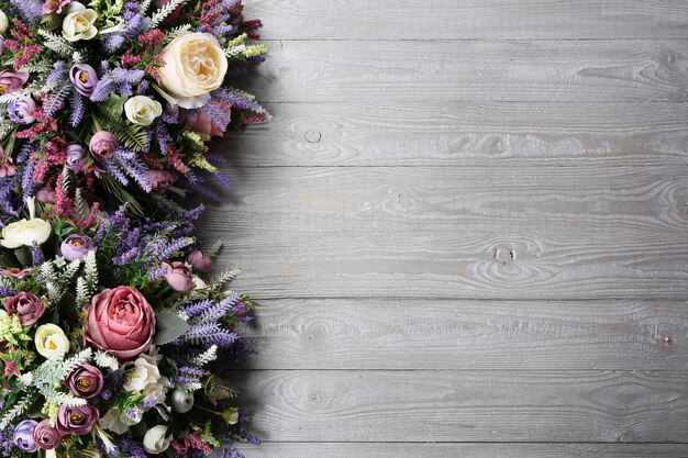 Floral arrangement on wooden texture background.