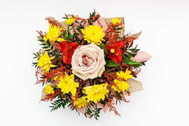 Floral arrangement yellow chrysanthemum and pink rose in flower bouquet on white surface