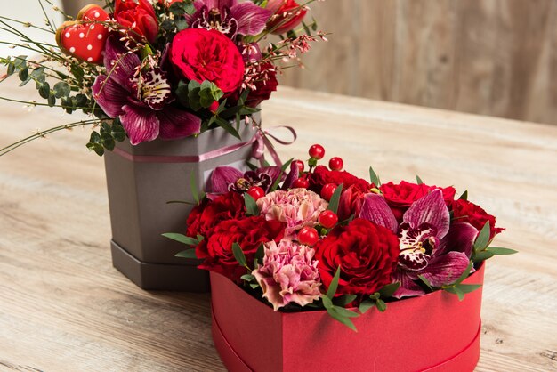 Photo floral arrangements in boxes on wooden table