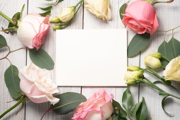 꽃 배경 및 빈 흰색 카드입니다. Eustoma, 유칼립투스 및 핑크 장미. 휴일 개념 및 복사 공간. 고품질 사진