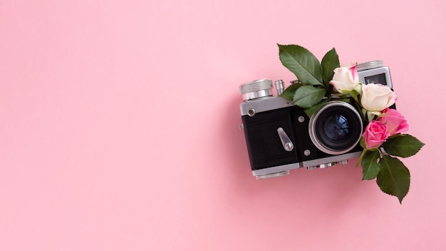 Floral composition with a wreath of pink roses and camera on pink background. Valentine's Day