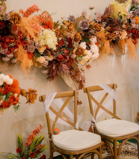 A floral display with a chair and a white chair with a white seat.