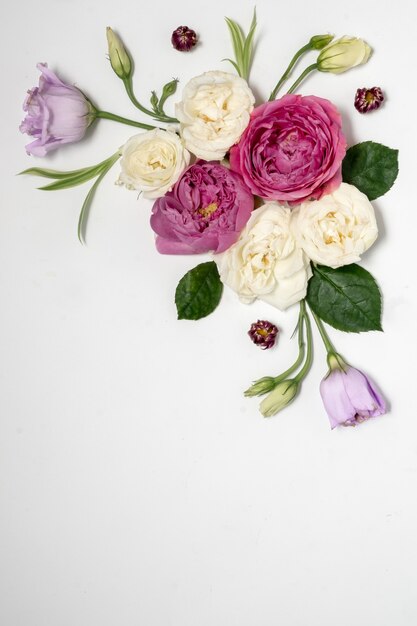 Foto cornice floreale su una superficie grigia. vista dall'alto e copia spazio. delicate rose lilla ed eustoma. composizione ad angolo. foto di alta qualità