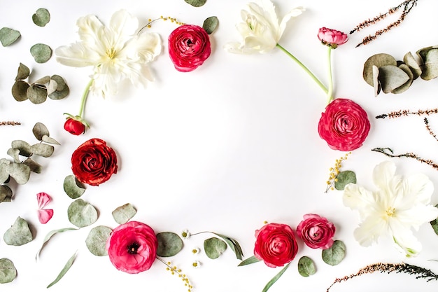 Cornice floreale di rose rosa e rosse o ranuncolo, tulipani bianchi e foglie verdi