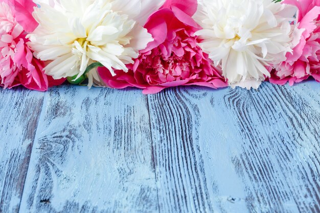 Floral frame with pink peonies on wooden