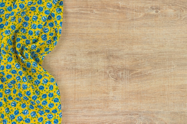 Floral pattern cloth napkin on wooden background.