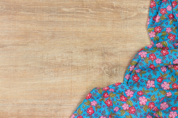 Floral pattern cloth napkin on wooden background. 