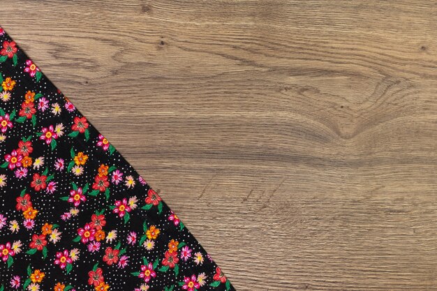 Floral pattern cloth napkin on wooden background. 