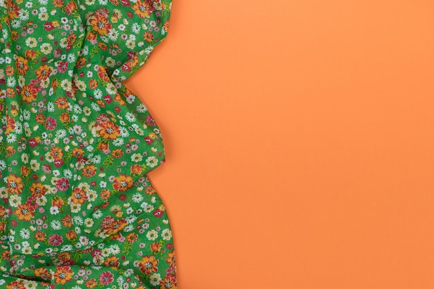 Floral pattern tablecloth on empty orange background