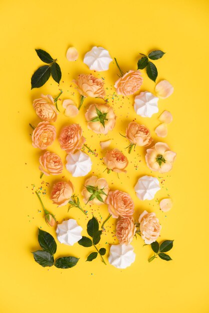 Floral pattern with pink roses and merengues on yellow background