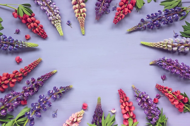 Floral purple background with lupins, top view. Empty place for Your text in the middle.