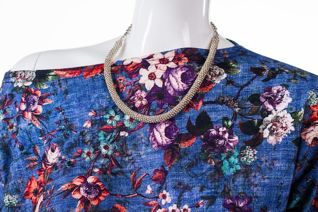 Floral top and silver necklace. female mannequin wearing bijouterie necklace. new accessory for young girls. merchandise at low price.