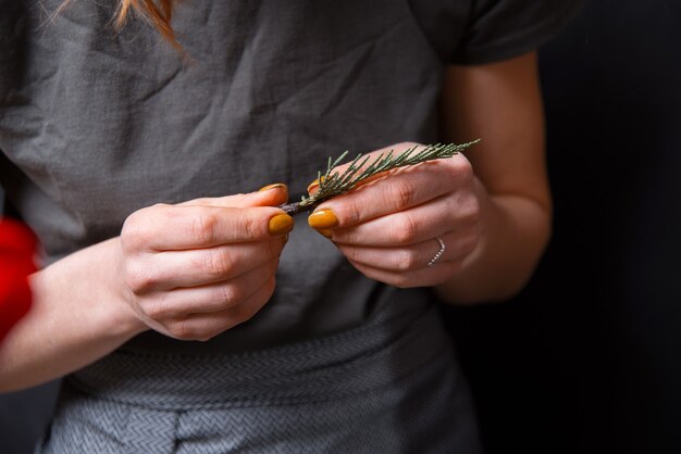 Floral vrouw met kleine brunch van dennen op donker