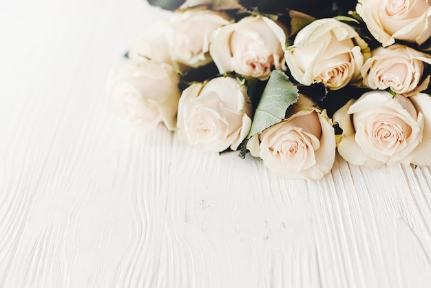 Foto floral wenskaart mockup witte rozen op houten achtergrond ruimte voor tekst bruiloft uitnodiging of happy mother day of valentines concept boeket van witte bloemen