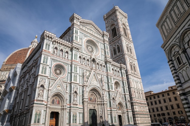 florence, italy - june 24, 2018: panoramic view of cattedrale di santa maria del fiore (cathedral of saint mary of the flower) and giotto's campanile. people walk on square in summer day