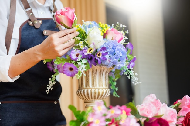 Fiorista che organizza bella maglia artificiale al negozio di fiori