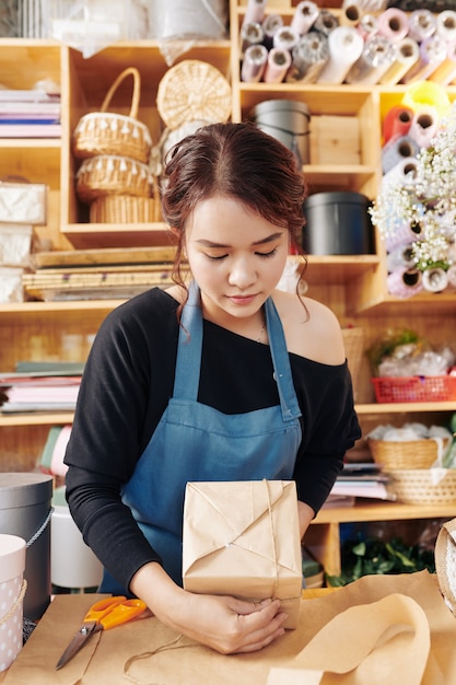 Florist concentrated on wrapping present