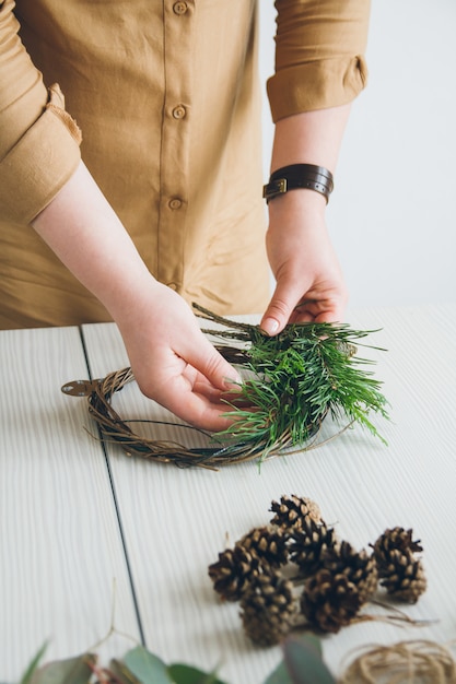 Florist decorator making Christmas wreath 