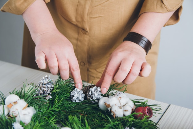 Florist decorator making Christmas wreath 