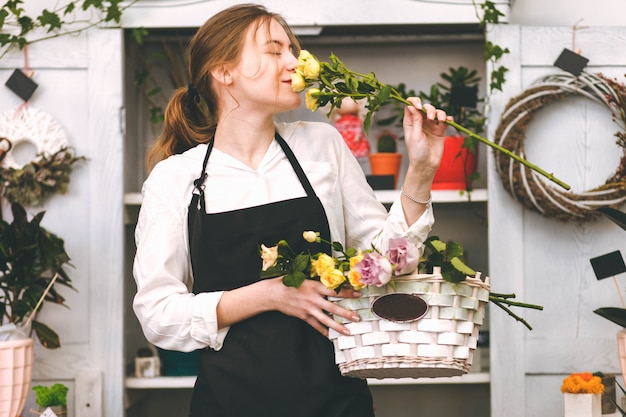 Florist of flower shop sniffing rose