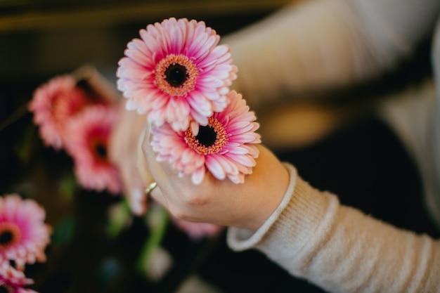 Florist holding two pink flowers