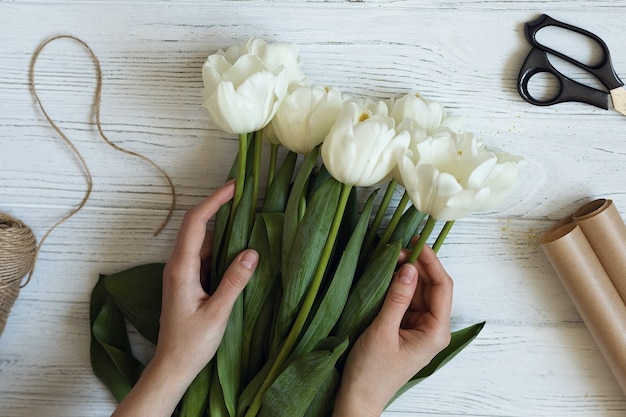 Florist makes a bouquet of white tulips