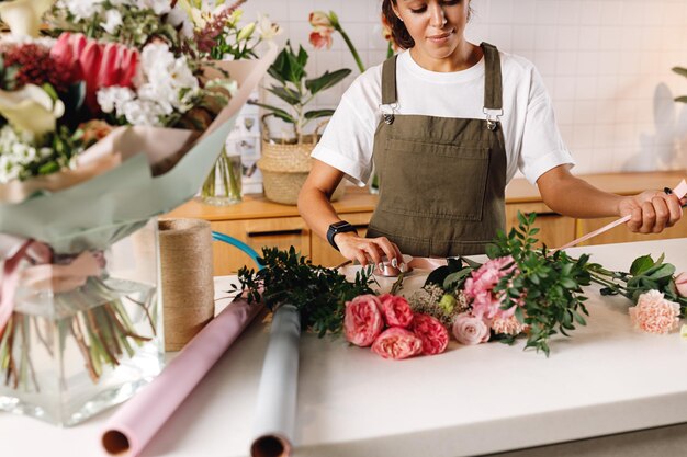 Foto fiorista che fa un bouquet di fiori al negozio