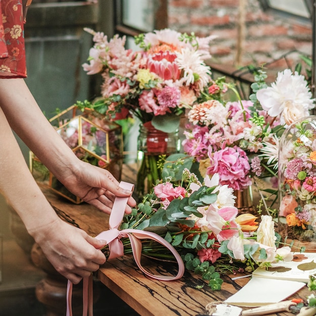 Photo florist tying a ribbon on a bouquet