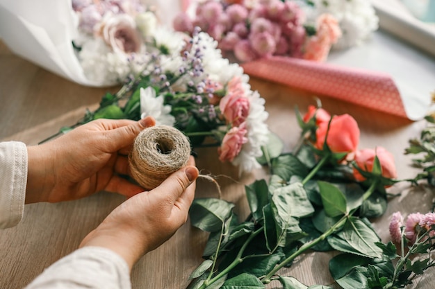 Foto fiorista al lavoro donna che fa decorazioni floreali d'autunno