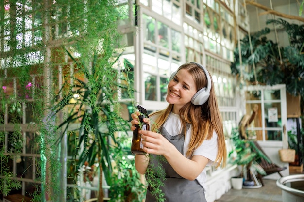 花屋は彼のワーク ショップでラップトップで作業します。起業家は開花植物の世話をします。