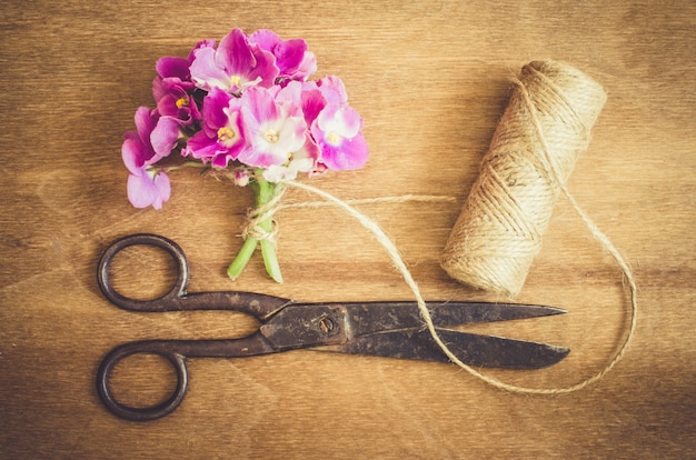 Floristic background. Flowers, scissors and rope.